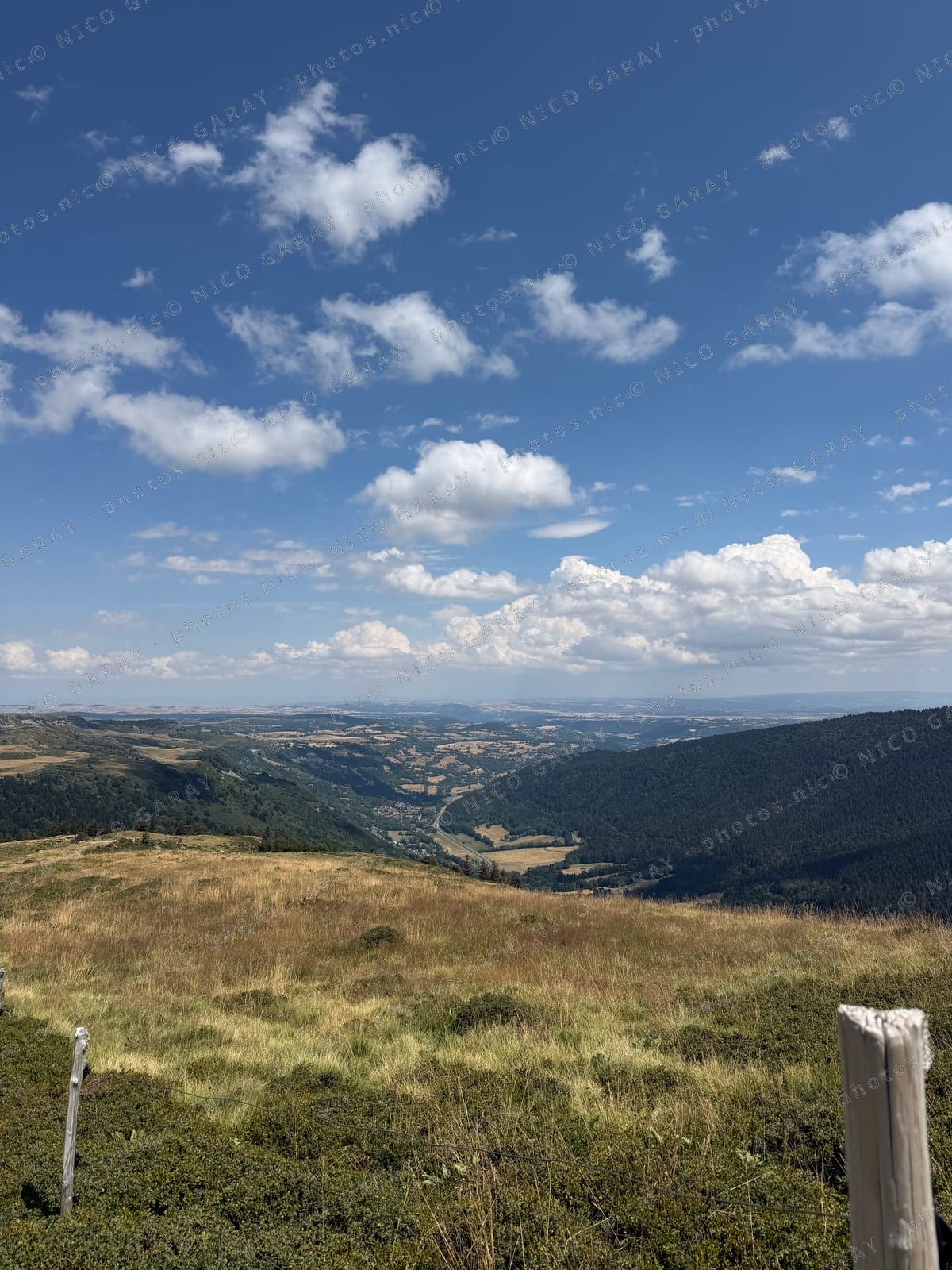 Vallée verdoyante sous un ciel de cumulus